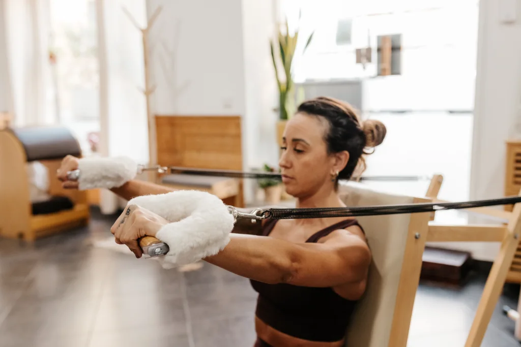Entrenamiento de pilates con máquinas para fortalecer brazos y postura en Sant Gervasi
